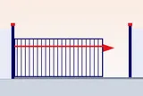 Side view of a sliding gate motor and rack along the base of the gate